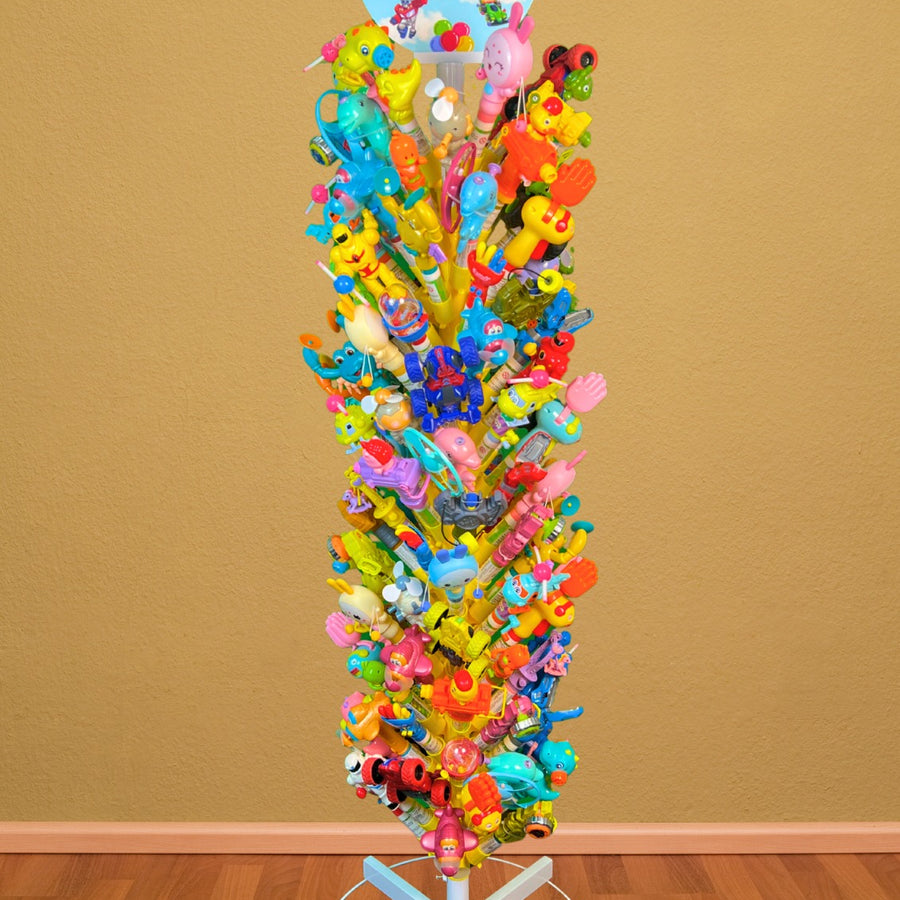 Colorful candy tree with various toys on a stand against a brown wall.